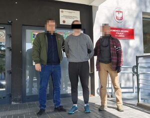 Policjanci prowadzą zatrzymanego mężczyznę.