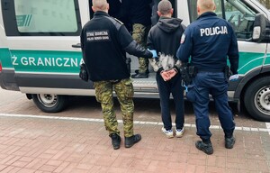 policjanci i funkcjonariusz Staraży Granicznej prowadzą zatrzymanego.