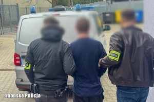 policjanci prowadzą zatrzymanego.