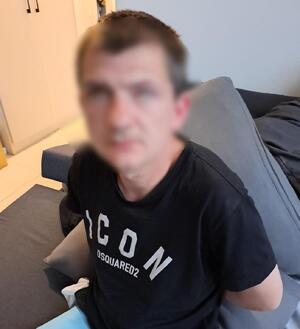 Zatrzymany mężczyzna zakuty w kajdanki.