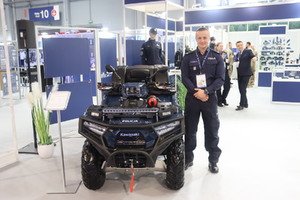 Zdjęcie przedstawia quada policyjnego oraz stojącego przy nim funkcjonariusza Policji