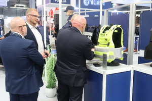 Zdjęcie przedstawia osoby oglądające policyjne kamizelki