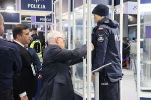 Zdjęcie przedstawia osoby oglądające mundur policyjny