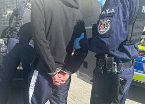 policjanci prowadza zatrzymanego.