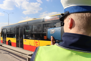 Zdjęcie przedstawia funkcjonariusza Policji z laserowym miernikiem prędkości
