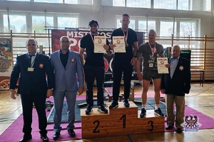 Ludzie na podium z pucharami i medalami.