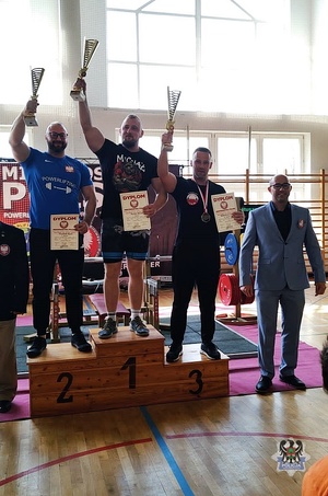Ludzie na podium z pucharami i medalami.