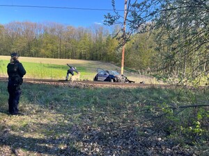 Samochód na drodze, mężczyzna wyciąga kobietę.