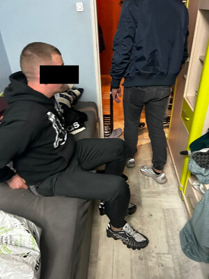 Zatrzymany siedzi na kanapie w pokoju.