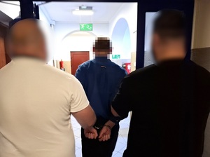 Policjanci prowadzą zatrzymanego.