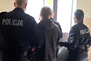 Policjanci prowadzą zatrzymanego.