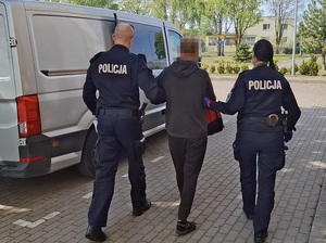 Policjanci prowadzą zatrzymanego.