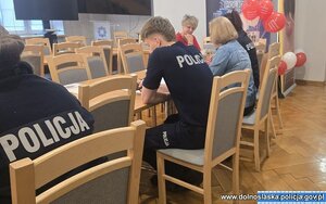 Policjanci siedzą przy stolikach.