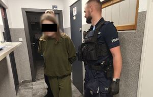 policjanci prowadzą zatrzymaną.