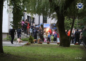 Ludzie zebrani przed budynkiem i kilku policjantów z psami.