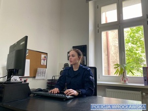 Policjantka siedzi przy biurku.