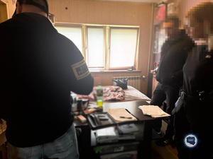 Troje policjantów przy stole na którym leżą różnego rodzaju dokumenty.