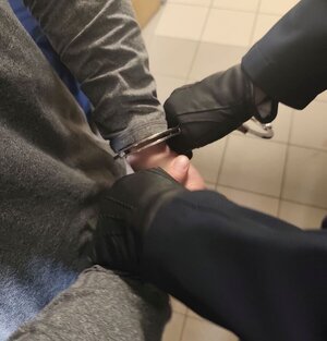 policjant zakłada kajdanki mężczyźnie.