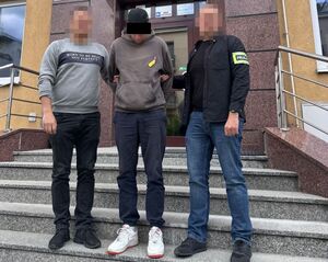 Dwaj policjanci ubrani po cywilnemu prowadzą zatrzymanego 36-latka.