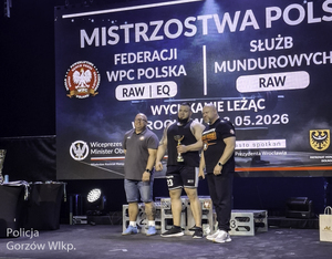 Trzej sportowcy przy podium.