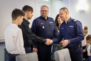 Uczestnicy spotkania w KGP. Policjant z rodziną oraz policjanci z komendantem głównym Policji na czele.