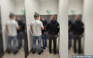 Dwaj policjanci prowadzą zatrzymanego.