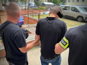 Dwaj policjanci z zatrzymanym mężczyzną.