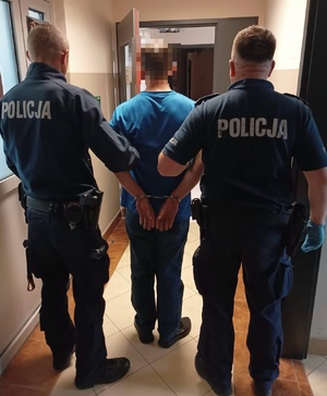 Dwaj policjanci z zatrzymanym.