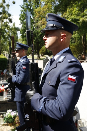 Dwaj policjanci na honorowej warcie przy grobie generała Marka Papały.