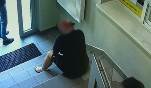 Siedzący na schodach mężczyzna.