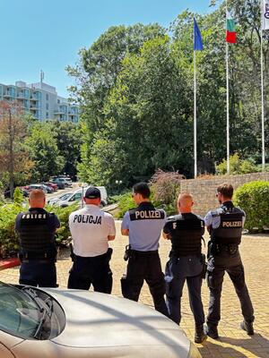 Pięciu umundurowanych policjantów z różnych krajów odwróconych tyłem.