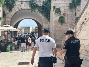Dwóch policjantów podczas patrolu na ulicy w tle zabytkowa budowla.