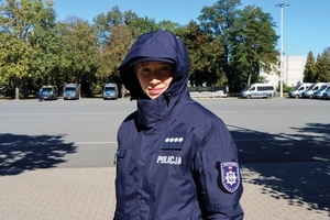 Policjantka w nowym umundurowaniu. Na głowie ma założony kaptur kurtki.