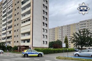 Policyjny radiowóz przed blokiem.