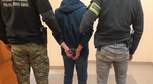 Dwoje funkcjonariuszy z zatrzymanym.