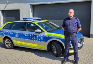 Policjant przy radiowozie.