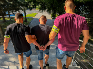 Policjanci prowadzą zatrzymanego.