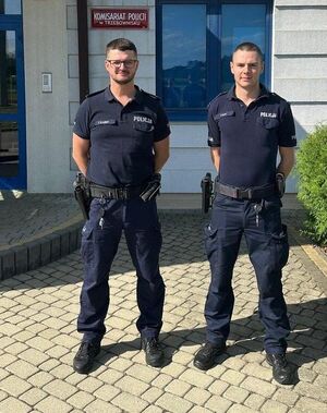 Dwaj policjanci pozują do zdjęcia.