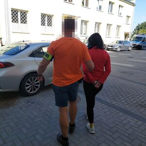 Policjant prowadzi zatrzymaną.
