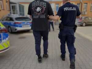 Zatrzymany prowadzony przez policjanta.