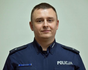 Policjant pozuje do zdjęcia.