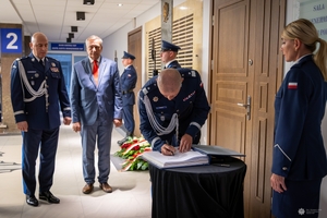 I zastępca komendanta głównego Policji wpisuje się do księgi pamięci.