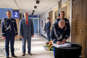 Zastępca komendanta głównego Policji w pisuje się do księgi pamięci.