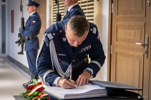 Zastępca komendanta głównego Policji w pisuje się do księgi pamięci.