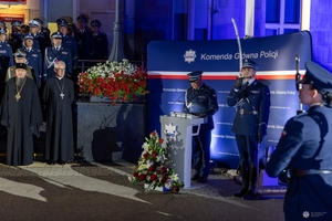 Uczestnicy uroczystości. Przy mównicy policjant, obok niego stoi funkcjonariusz z szablą uniesiona do góry.