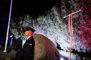Policjanci stojący przy obelisku na warcie honorowej.