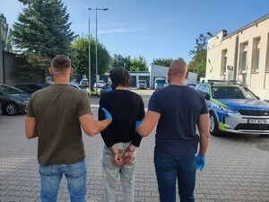 Funkcjonariusze policji w cywilu zatrzymują mężczyznę.