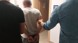 Funkcjonariusze w cywilu zatrzymują mężczyznę.