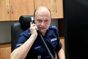 Policjant rozmawia przez słuchawkę telefonu.