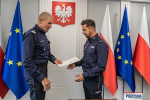 I Zastępca Komendanta Głównego Policji ściska dłoń funkcjonariuszowi gratulując.